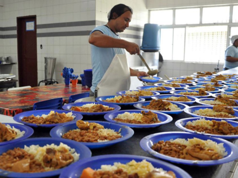 Pessoa servindo merenda na escola. Fonte: Associação Brasileira de Municípios. Divulgação [http://www.abm.org.br/estados-e-municipios-terao-r-3841-milhoes-para-aplicar-na-merenda-escolar/]